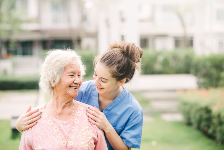 Caregiver with Asian elderly woman outdoor