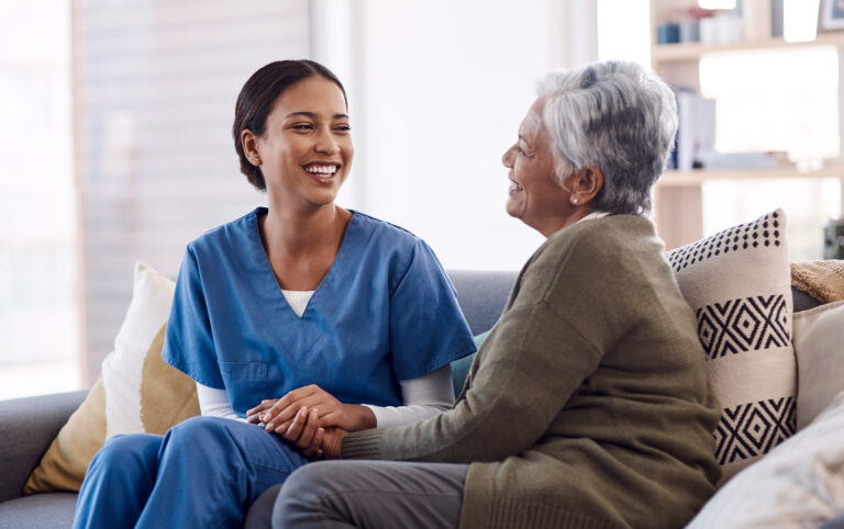 Retirement, sofa and caregiver with senior woman for conversation, chatting and support in living room